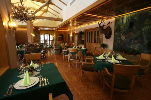 斯特拉科尼采巴斯塔狩猎旅馆的用餐室配有绿色的桌椅