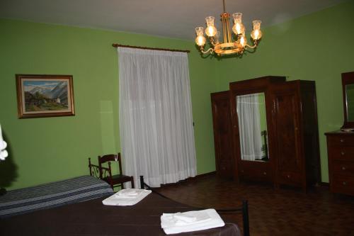 Torre le NocelleAgriturismo Casale 1921的一间卧室设有绿色的墙壁、一张床和一个吊灯。