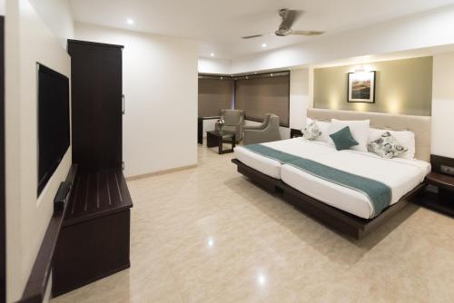 孟买Hotel Le Grande - Mumbai International Airport的酒店客房,配有床和电视