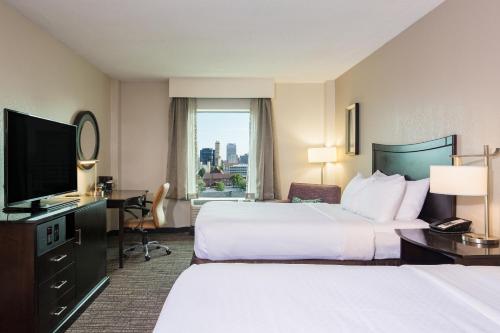 孟菲斯孟菲斯市中心皇冠假日酒店的酒店客房设有两张床和一台平面电视。