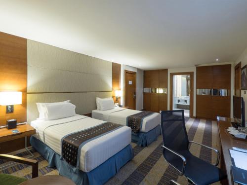 宿务Lex Hotel Cebu的酒店客房配有两张床和一张书桌