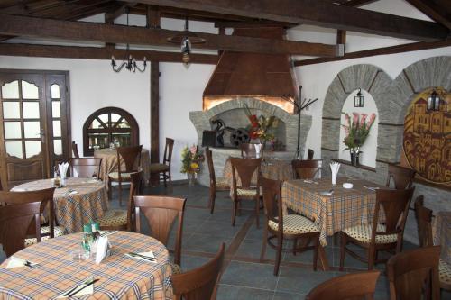 阿塞诺夫格勒老时光酒店的一间带桌椅和壁炉的餐厅