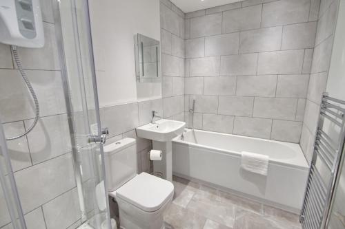 朴次茅斯Courtside Apartment Southsea的浴室配有卫生间、浴缸和水槽。