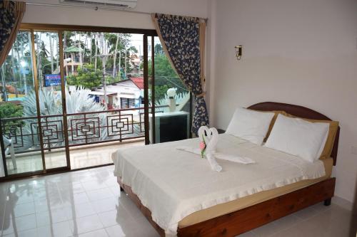 拉迈苏梅岛旅馆的一间卧室设有一张床和一个大窗户