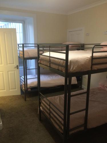 爱丁堡爱丁堡西城区旅舍的带三张双层床和一扇门的房间