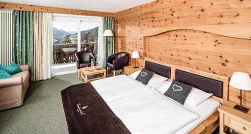 塞尔瓦迪加尔代纳山谷大陆酒店的一间卧室配有一张木墙床