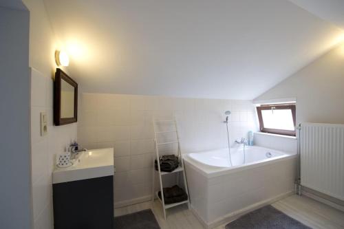 BoutersemGuesthouse Biolleke的白色的浴室设有浴缸和水槽。