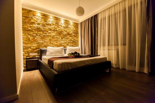 克卢日-纳波卡Cluj Business Class的一间卧室设有一张床和砖墙