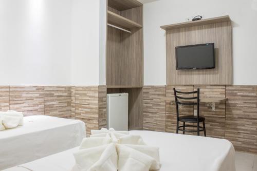 若昂佩索阿波萨达亚特兰帝卡酒店的客房设有两张床和一台墙上的电视