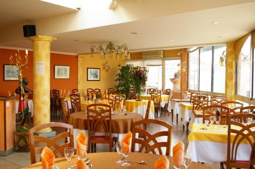 帕米耶霍伊高赫蒙酒店的餐厅设有桌椅和黄色的墙壁