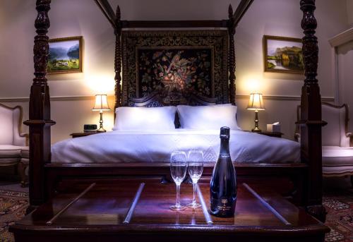 弗里曼特弗里曼特尔佛特吉尔住宿加早餐旅馆的一张带一瓶葡萄酒和两张眼镜的桌子床