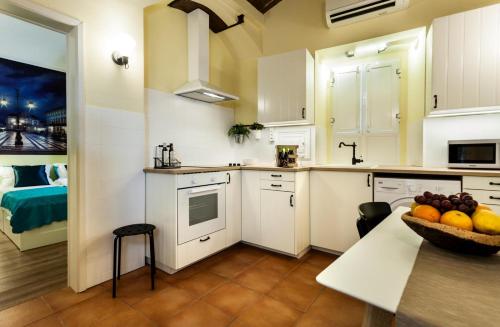 埃武拉Alfar Aqueduct - Évora House的厨房配有白色橱柜和一碗水果放在桌子上