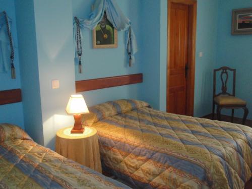 Palazuelo de VedijaFuerte de San Mauricio的一间卧室设有两张床和一张桌子上的台灯。