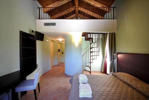 拉奎拉玛吉欧内巴巴雷黎莱斯酒店的一间卧室设有一张床、一台电视和楼梯。