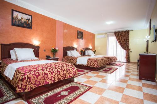 马拉喀什大使酒店的酒店客房带两张床和橙色墙壁