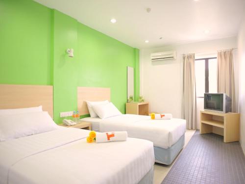 玻璃市港口玻璃市瓜拉T酒店的酒店客房设有两张床和电视。