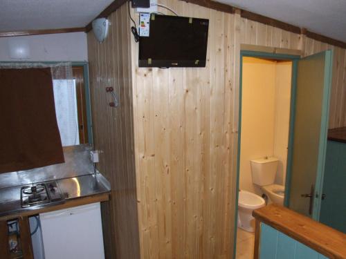 卡塔尼亚露营爱奥尼亚酒店的一间带卫生间的浴室和墙上的电视