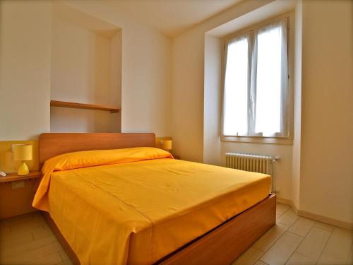 阿尔杰尼奥洛坎达波斯塔酒店的一间卧室配有一张带橙色床罩的床和窗户。