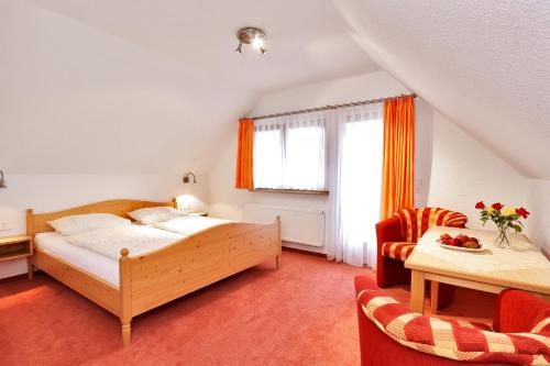 伦茨基希瓦尔德温克尔酒店的卧室配有一张床和一张桌子及椅子