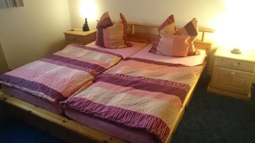 Bornich罗蕾莱河畔公寓的一间卧室配有两张带粉色和紫色枕头的床