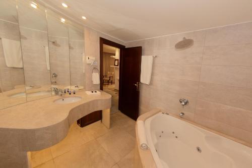 纳布卢斯Royal Suites的带浴缸、水槽和浴缸的浴室