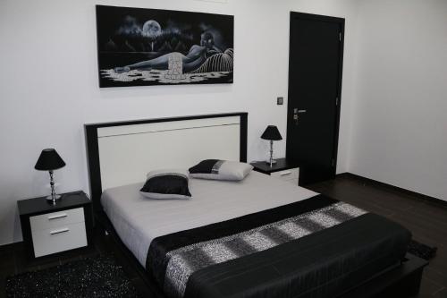CandeláriaVivenda Paraíso的卧室配有一张带白色床单和枕头的大床。