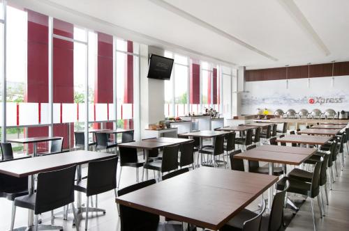 马卡萨佩塔拉尼爱玛瑞丝酒店 - 望加锡的用餐室设有桌椅和窗户。