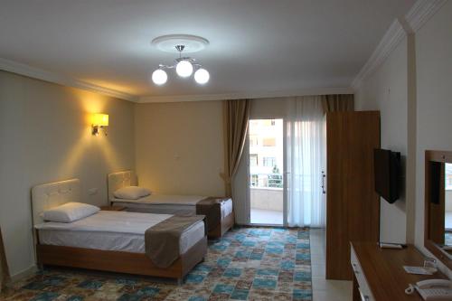 MutDeveci Hotel的酒店客房设有两张床和电视。