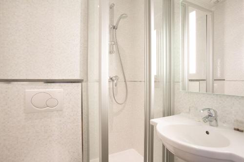 巴黎圣拉扎尔贝尔维尤酒店的带淋浴和盥洗盆的白色浴室