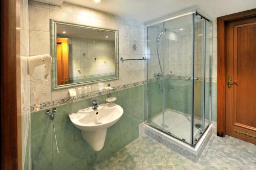 布拉迪斯拉发阿普兰德佩鲁贾城市酒店的一间带水槽和玻璃淋浴的浴室