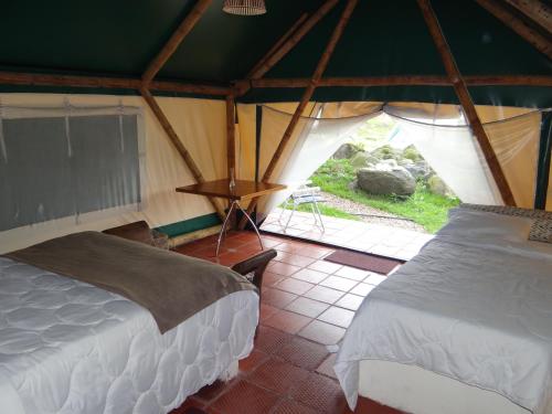 圣弗朗西斯科Glamping El Establo的帐篷内带两张床的房间