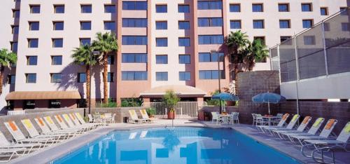 拉斯维加斯卡利吉酒店的酒店游泳池设有椅子,酒店大楼