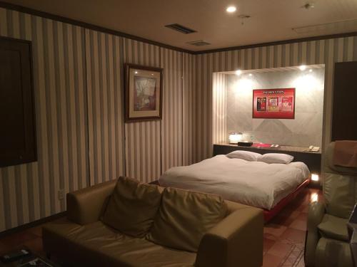 滨松幻想情趣酒店（仅限成人入住）的酒店客房,配有床和沙发
