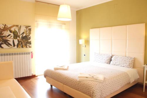 罗通达B&B da Peppe的一间卧室配有一张大床和大型白色床头板