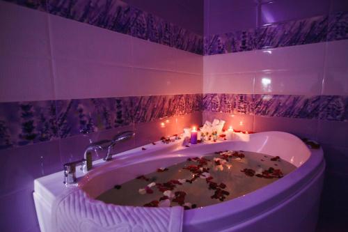 克麦罗沃Sport Hotel Maximum的紫色浴室设有浴缸和蜡烛