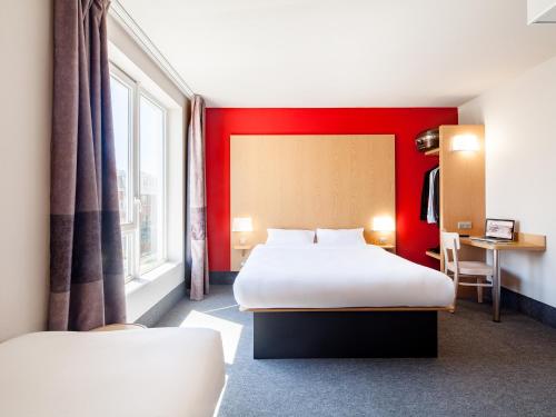 博比尼B&B HOTEL Paris Est Bobigny Université的酒店客房设有两张床和红色的墙壁。