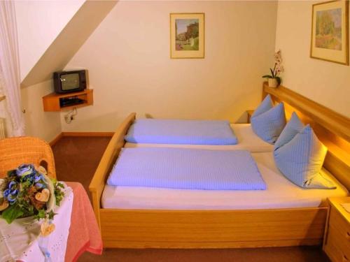 杜尔巴赫Gasthaus Hohberg的一间卧室配有一张带蓝色枕头的木床。