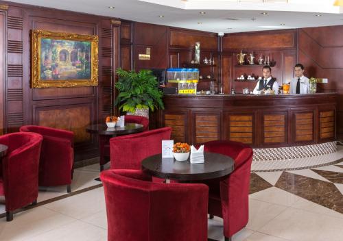 多哈旅客酒店的一间设有红色椅子的餐厅和一间酒吧