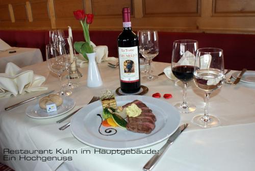 达沃斯Kessler's Kulm Gästehaus的一张桌子,上面放着一盘食物和一瓶葡萄酒