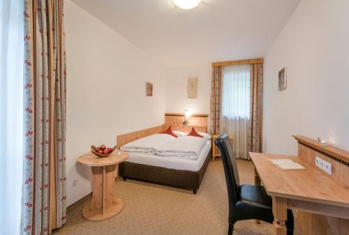 泰根塞韦斯特霍夫山屋酒店的一间卧室配有一张床、一张桌子和一张桌子