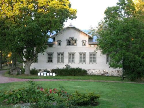 SaltvikKvarnbo Pensionat的前面有一棵树的白色房子