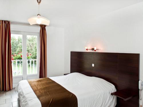 布拉西厄洛莉德城堡酒店的一间卧室设有一张大床和一个窗户。