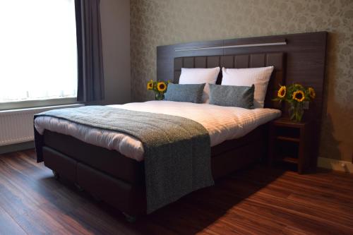 阿姆斯特丹OZO Hotels Armada Amsterdam的一间卧室配有一张带鲜花的大床
