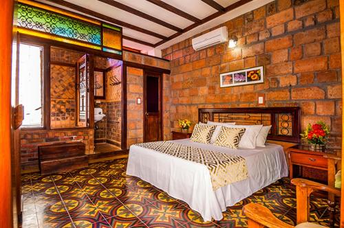 圣菲德安蒂奥基亚Hosteria de la Plaza Menor的一间卧室设有一张床和砖墙