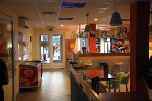 塞格德Teke Bowling Centrum és Sport Panzió的一间带柜台的餐厅以及一个带椅子的酒吧