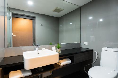 曼谷菲英岛酒店的一间带水槽、卫生间和镜子的浴室