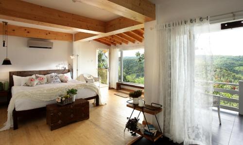 提喀迪Hills & Hues的一间卧室设有一张床和一个大窗户