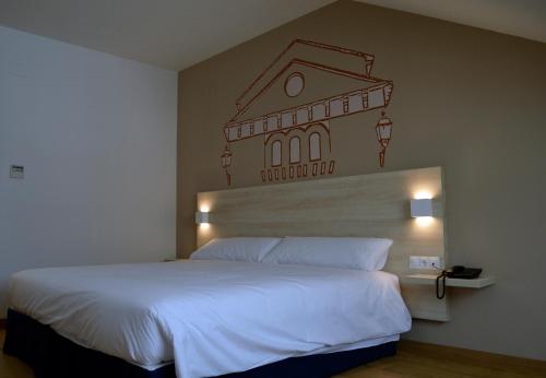 GraenaHotel Balneario de Graena的卧室配有一张白色大床,墙上设有一座建筑