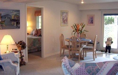 波斯特福尔斯River Cove Elegant Waterfront Bed & Breakfast的一间带桌椅的客厅和一间卧室