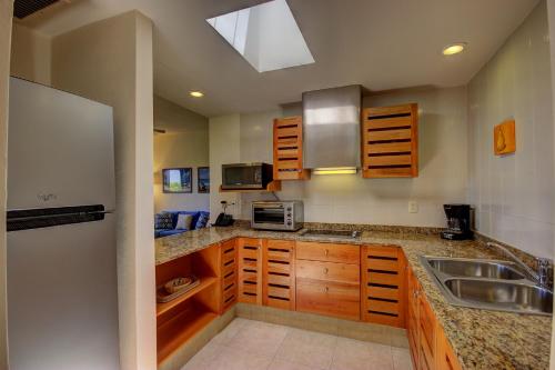 普拉亚卡门玛雅海滨度假套房酒店的一个带木制橱柜和水槽的厨房
